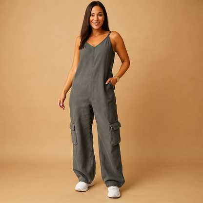 Women’s denim jumpsuit with V-neckline and open back featuring crossed straps, perfect for summer, festivals, and casual outings.